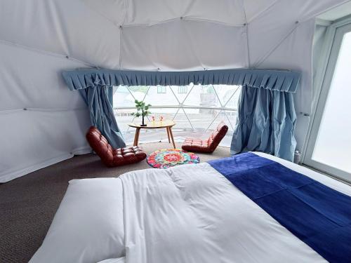 a bedroom with a tent with a bed and a table at ジーアール柳井 in Yanai