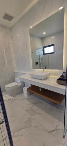 a bathroom with a sink and a toilet and a mirror at ThreeTreesSamuiPoolVilla in Ban Thung