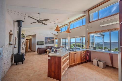 a large kitchen with a living room with windows at Moonrise Cove in Pelican Lagoon