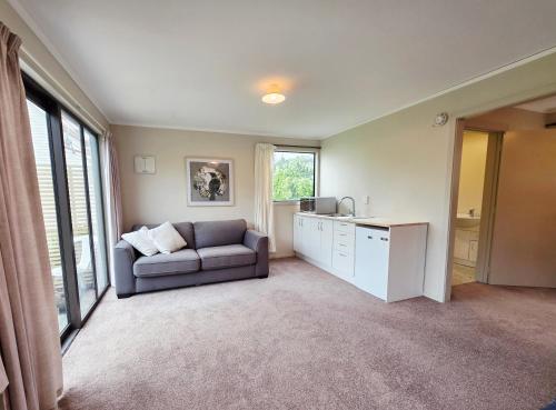 a living room with a couch and a table at Saddleview Cottage-Horse and Trailer friendly in Mosgiel