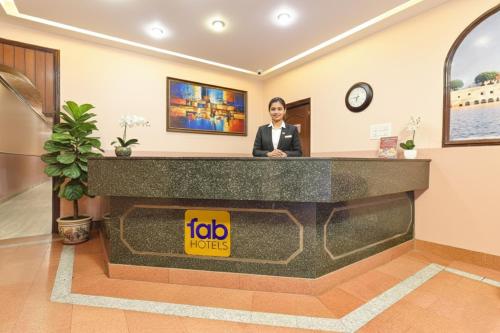 a woman standing at the reception desk of a hotel lobby at FabHotel Jai Mangal Palace - Sindhi camp bus stand, Jaipur railway station,Sindhicamp metro station in Jaipur