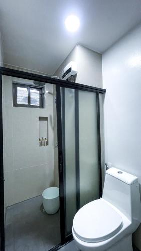 a bathroom with a toilet and a glass shower at WV 32 Urban Scenic Studio in Sampong