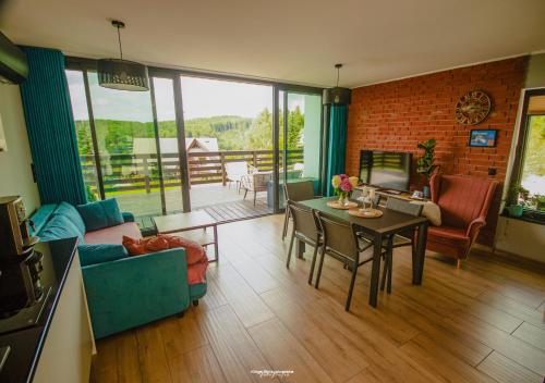 a living room with a couch and a table at Domki na szczycie in Krzeszna