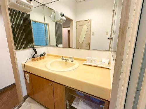 a bathroom with a sink and a mirror at ジーアール柳井 in Yanai