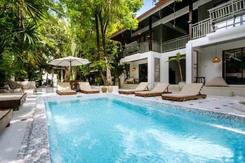 a swimming pool with lounge chairs and a house at Huge 8 Bedrooms Pool Villa, Chiang Mai gem, Tanpuri Patan, perfect for Groups in Chiang Mai