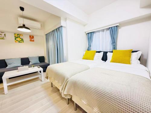 a bedroom with two beds and a couch at REGNO COMFORT ASAKUSA Ⅳ in Tokyo