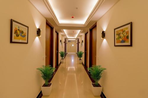 a corridor in a hotel with potted plants at FabHotel Pitampura in New Delhi