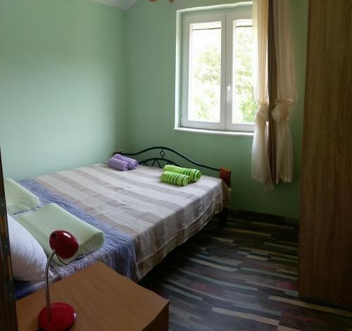 a bedroom with a bed and a window at Apartments Sadina in Skradin