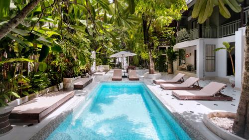 a pool with chaise lounges and a resort at Huge 8 Bedrooms Pool Villa, Chiang Mai gem, Tanpuri Patan, perfect for Groups in Chiang Mai