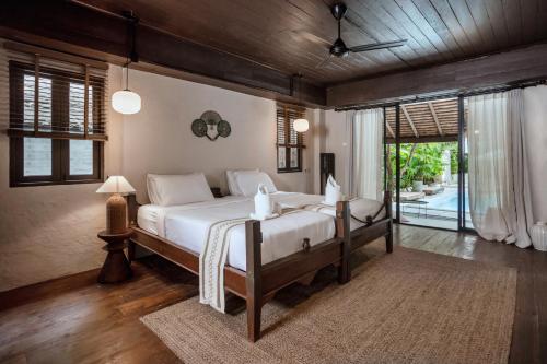 a bedroom with a large bed with white sheets at Huge 8 Bedrooms Pool Villa, Chiang Mai gem, Tanpuri Patan, perfect for Groups in Chiang Mai