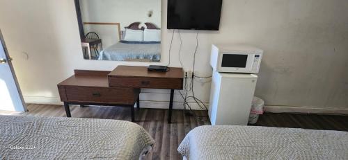 a room with a bed and a desk with a microwave at Town Inn Motel in Standish