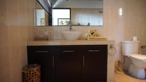 塞米亚克Tahoma Villas Seminyak by ABM的浴室里有洗手池、马桶和镜子。