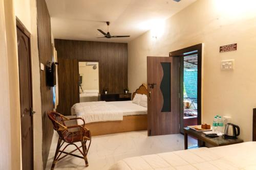 a bedroom with a bed and a chair in a room at The Whistling Pine Woods in Varagampadi