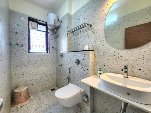 a bathroom with a sink and a toilet and a mirror at Romantic Goa Studio with Mangrove view - Walk to Candolim Beach, Ideal for Couples in Candolim
