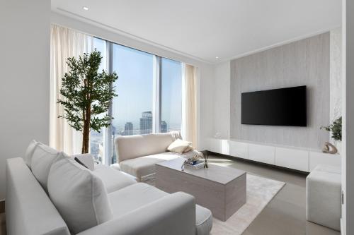 a living room with white furniture and a large window at Maison Privee - City Heights Retreat with Panoramic Skyline Views in Dubai