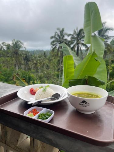 a tray with a bowl of soup and a plate of food at AJA Tumpaksewu Homestay in Lumajang