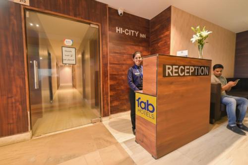 a woman standing next to a reception door in a elevator at FabHotel Penthouse - A K Dev Road in Guwahati
