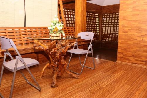 a table with two chairs and a table with flowers on it at Athithi Inn Homestay in Vaduvanchal