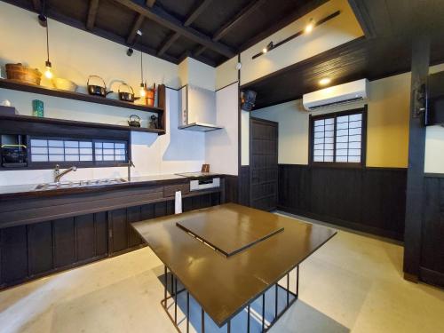 a kitchen with a table in the middle of it at 農家体験民宿 古民家 薄衣 in Ichinoseki