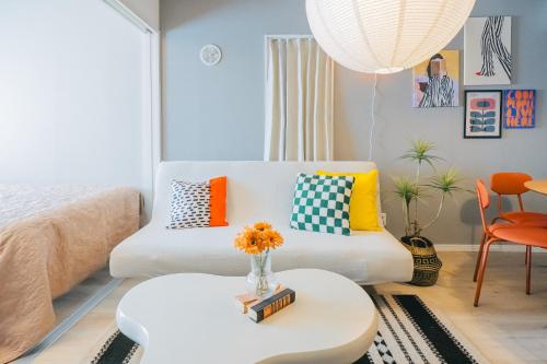 a living room with a couch and a table at Otter Stay Lite - Shinsakae in Nagoya
