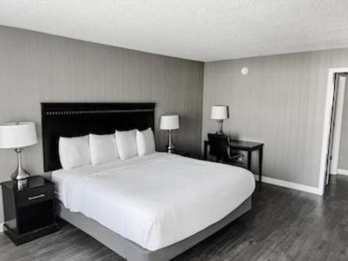 Un dormitorio con una gran cama blanca y dos lámparas. en The Georgian Resort, en Lake George