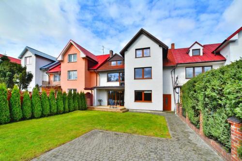 a large house with red roofs and a yard at Holiday home 200 qm, Kolobrzeg in Kołobrzeg