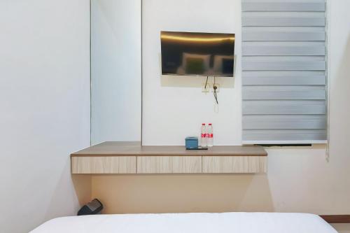 a bedroom with a bed and a tv on a wall at Urbanview SANT Hotel Syariah near Stasiun Tegal in Tegal
