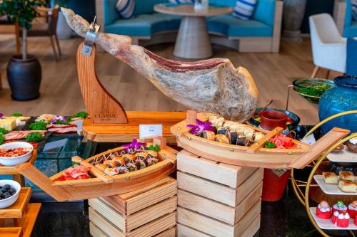 Un buffet con diferentes tipos de comida en bandejas de madera. en Sala Danang Beach Hotel, en Da Nang