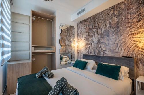 une chambre avec un grand lit avec des oreillers verts dans l'établissement Appartement proche croisette, à Cannes