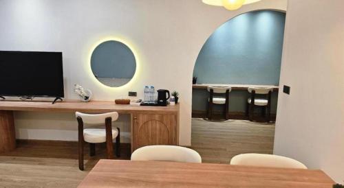a room with a desk with a television and chairs at The Bed Hotel Hatyai in Hat Yai