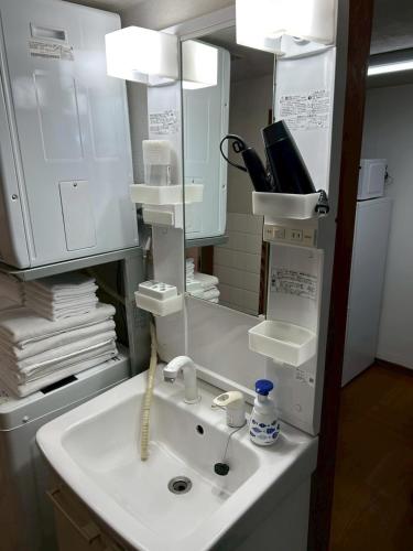 a bathroom with a sink and a mirror at Family Home Osaka Awaji Guest House in Osaka