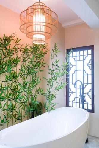 a bathroom with a bath tub and plants at Chinatown No9 Boutique Hotel in Bangkok