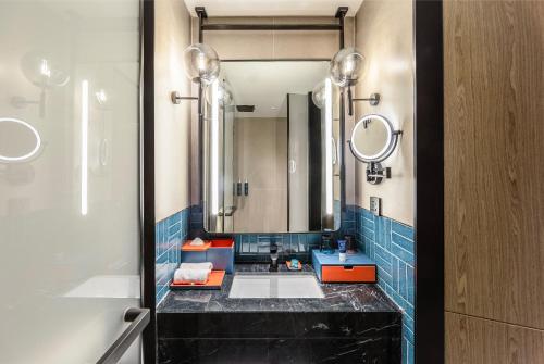 un baño con lavabo y espejo en Four Points by Sheraton Yantai Zhifu, en Yantai
