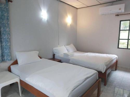 a room with two beds and a window at Chill Beach Resort in Pathiu