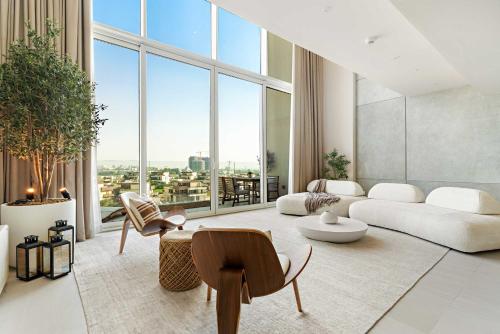a living room with a white couch and a large window at Silkhaus Vacation Homes Sea View 1BR in Mamsha Al Saadiyat at Azure in Abu Dhabi