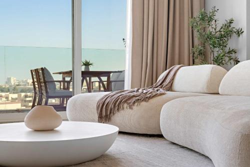 a living room with a couch and a table at Silkhaus Vacation Homes Sea View 1BR in Mamsha Al Saadiyat at Azure in Abu Dhabi