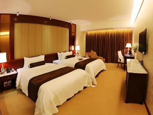PingzhouにあるFoshan Jubilee Hotelのベッド2台とテレビがあるホテルの部屋