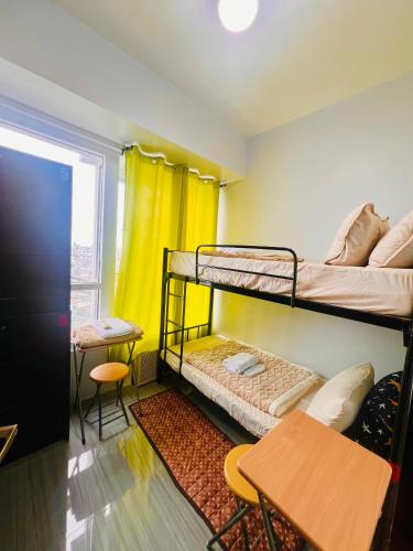 a room with two bunk beds and a table at Mezza Residences in Manila