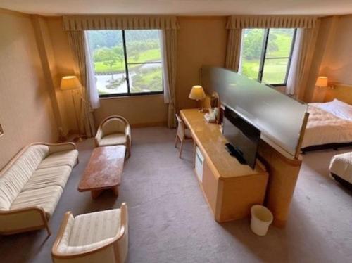 une chambre avec un grand lit et un bureau avec une télévision dans l'établissement Zuien Country Club Century Fuji Course, à Manzawa
