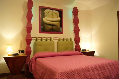 a bedroom with a bed with a red bedspread at Villa Masseria Marini in San Giuseppe Vesuviano