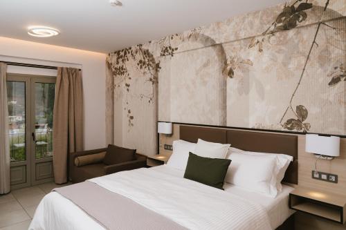 a hotel room with a bed and a chair at Trofonios Boutique Hotel in Levádeia