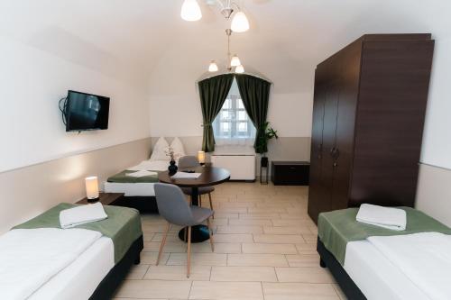 a hotel room with two beds and a table at River Apartmanház in Jászberény
