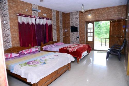 a bedroom with two beds and a television in it at SRI RANGA RESIDENCY in Māvingundi