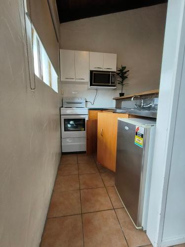a small kitchen with a refrigerator and a stove at Aladdin Motel in Auckland