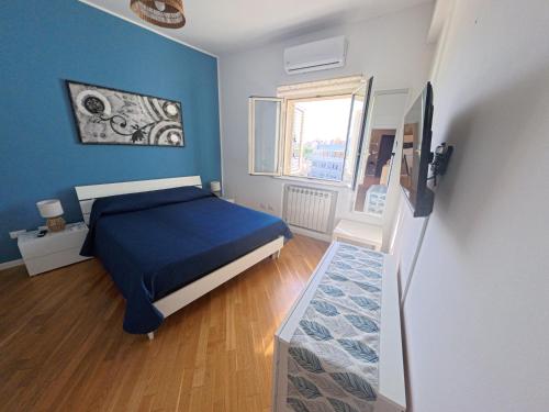 a blue bedroom with a bed and a window at Il Balcone sul mare - free parking & relax in Palermo