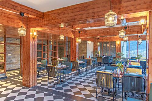 Un restaurante con paredes de madera y mesas y sillas. en Echor Himalayan Aurum Manali, en Manali