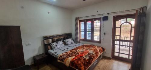 a bedroom with a bed in a room with a window at Peace Yard in Dharmsāla