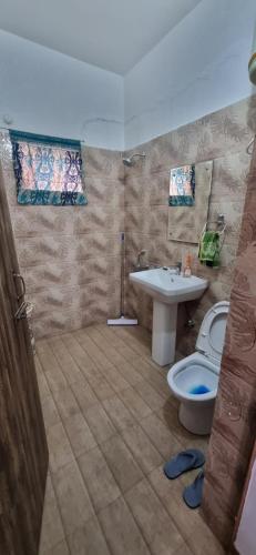 a bathroom with a toilet and a sink at Peace Yard in Dharmsāla