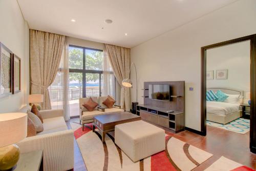 a living room with white furniture and a large mirror at Luxe Getaways Royal Amwaj Palm Jumeirah Resort Apartment Holiday Home in Dubai