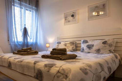 コネリアーノにあるANGELA GUEST HOUSE in centro storicoのタオルが敷かれたベッドのある寝室